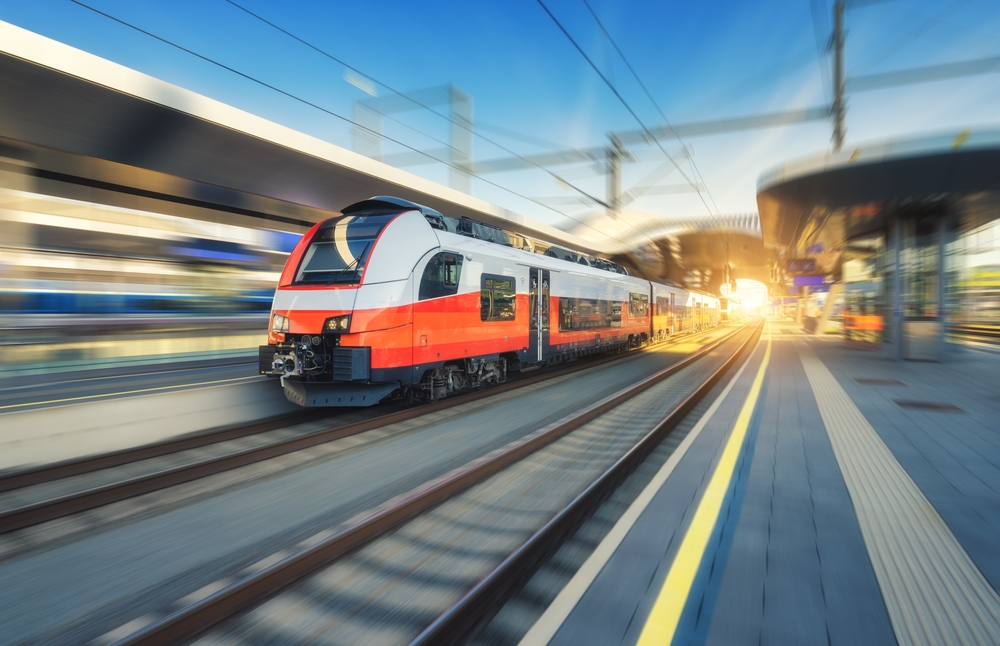 High-speed,Orange,Passenger,Train,Moving,At,Railway,Station,Platform,At